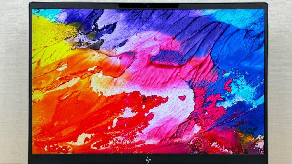 HP OmniBook 7 16-ayのディスプレイを撮影。カラフルな画像を表示し、他機種と色域を比較する。本機はsRGB 100％で色が鮮やかなのが見て取れる