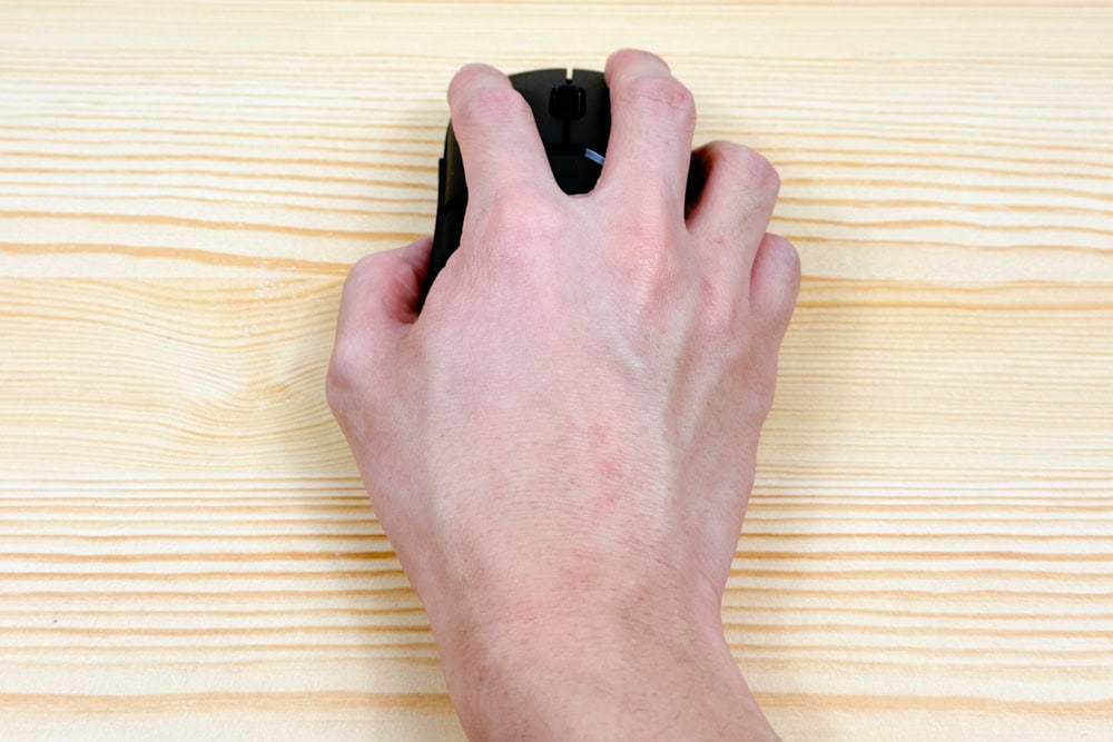 HyperX Pulsefire Saga Pro Wireless ゲーミングマウスを強く手で握っている写真。