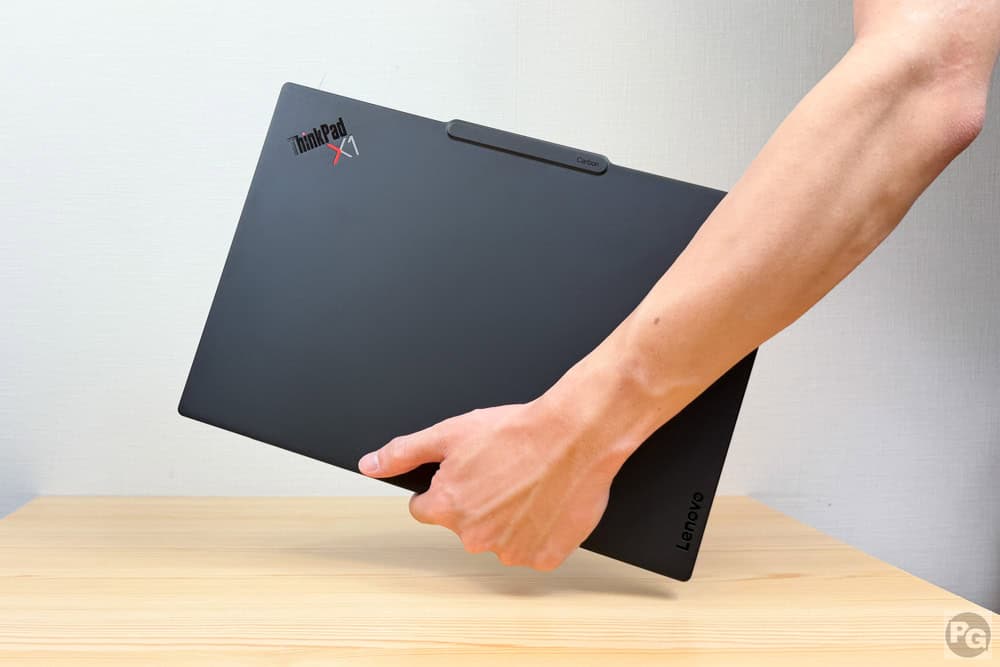 Lenovo ThinkPad X1 Carbon Gen 14 ​Aura Editionを軽々持ち上げて持ち運ぶ様子