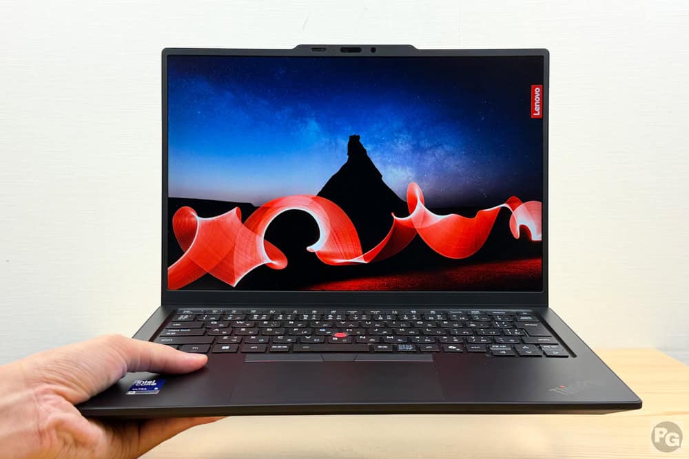 Lenovo ThinkPad X1 Carbon Gen 14 ​Aura Editionを片手で軽々持っている画像。最軽量モデルは977g